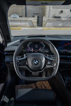 Luxury car interior featuring a sleek steering wheel and digital dashboard display.