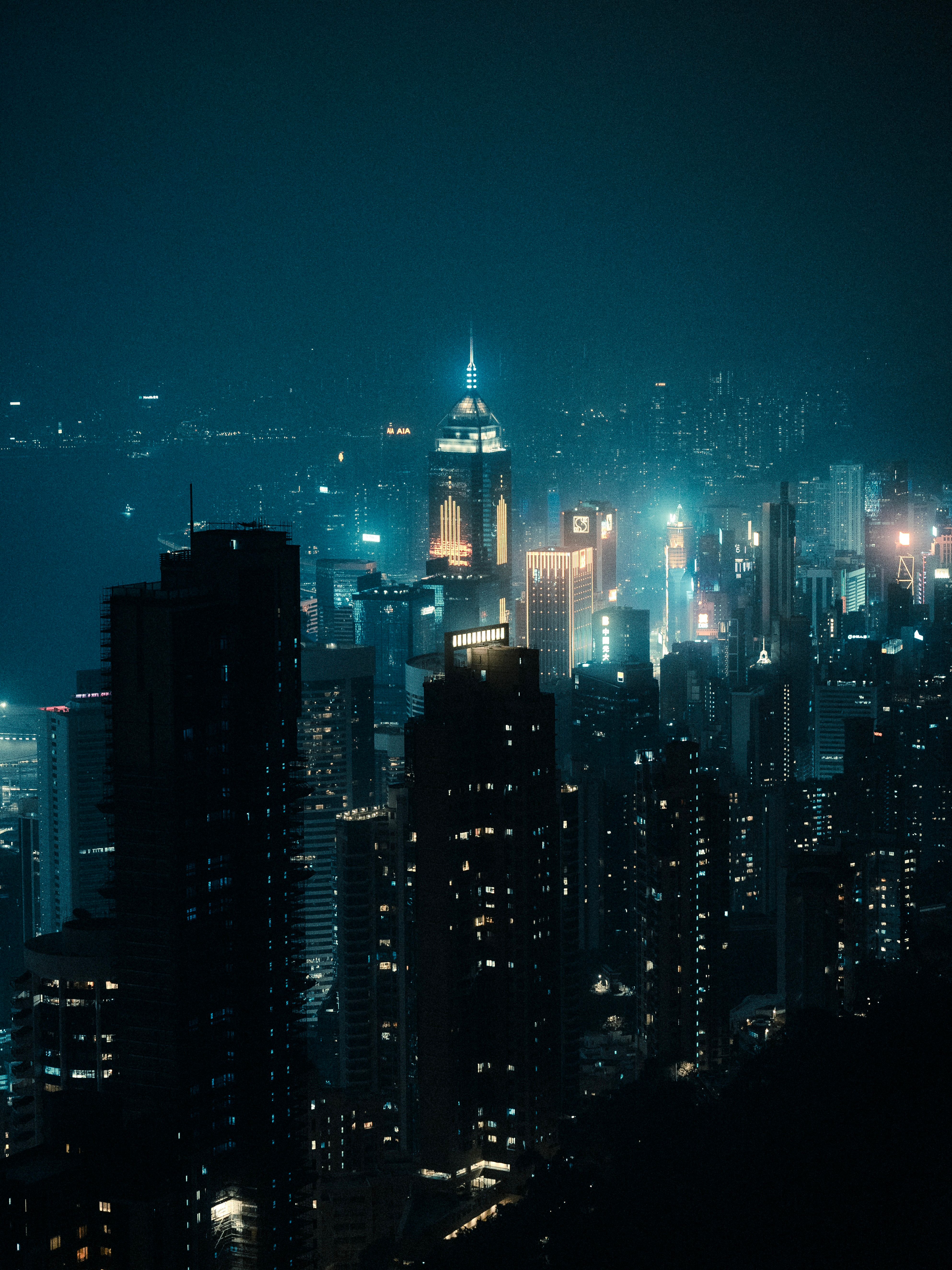 Stunning night view of Hong Kong skyline with illuminated skyscrapers reflecting on water.