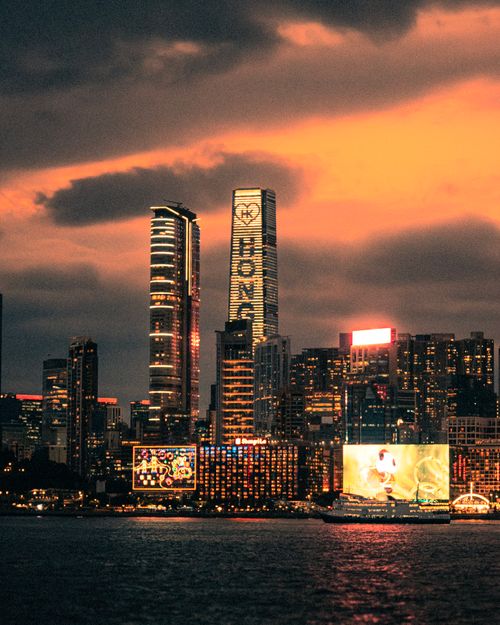 Free Stunning cityscape featuring illuminated skyscrapers against a vivid sunset sky, capturing urban energy. Stock Photo