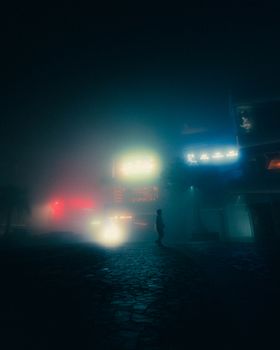 A mysterious silhouette walking in a foggy street illuminated by colorful neon lights.
