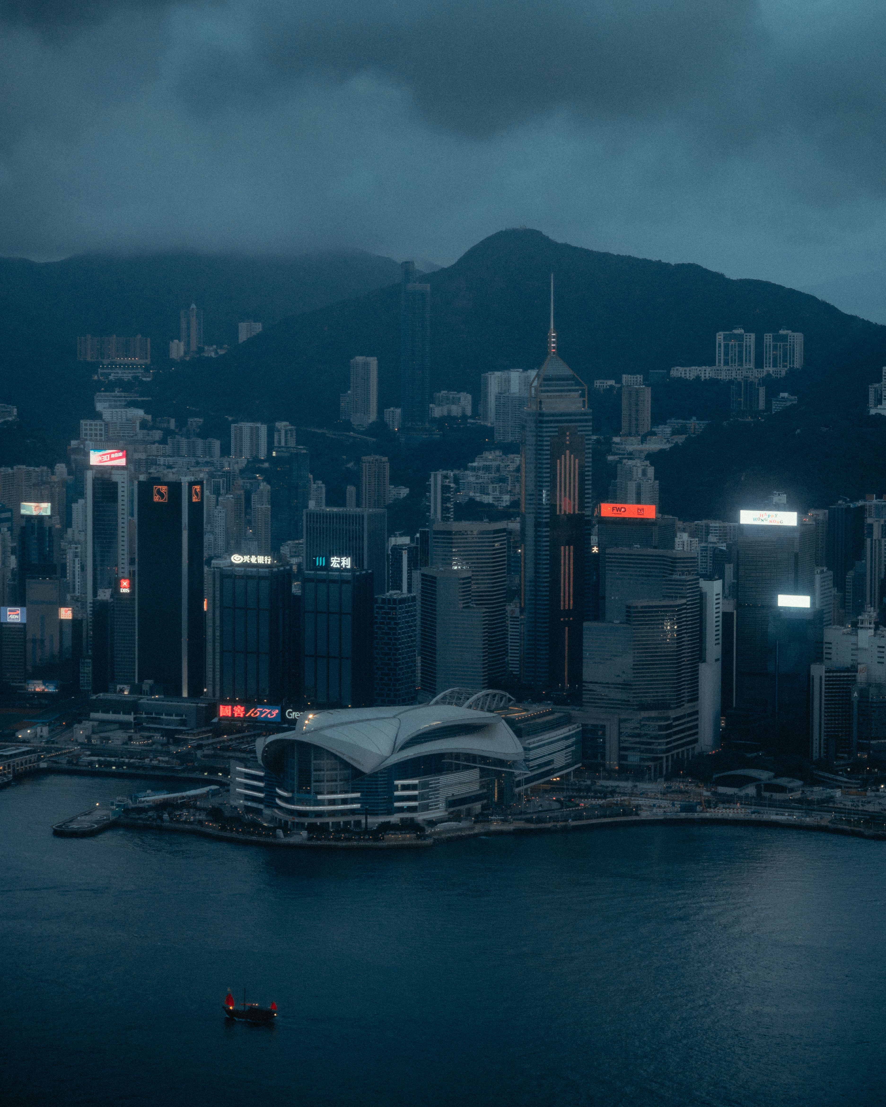 Aerial view of Hong Kong's skyline with dramatic evening clouds over Victoria Harbour.