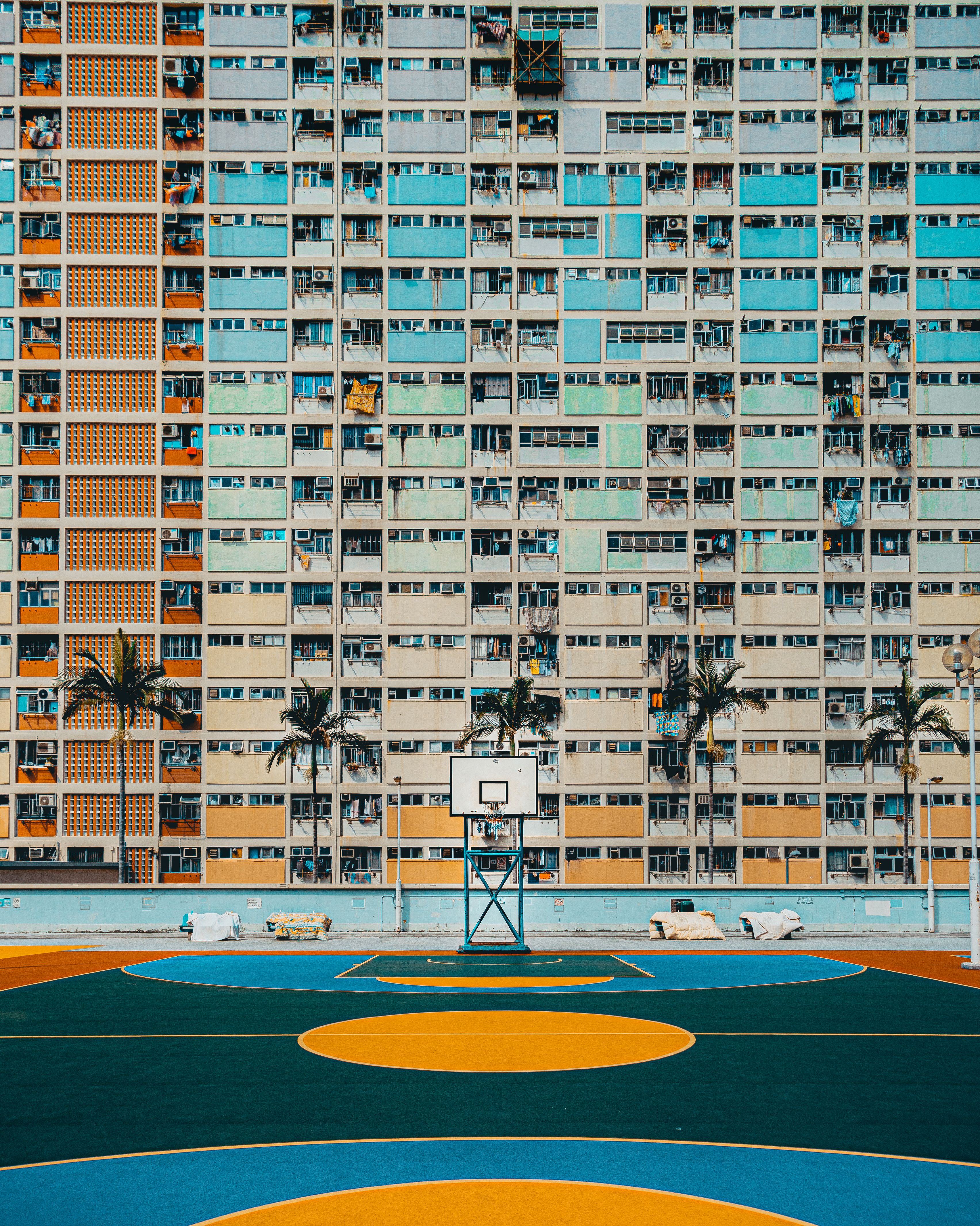 Colorful Choi Hung Estate with a vibrant basketball court, capturing urban life and architecture.