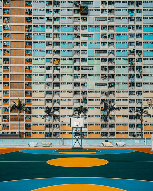 Colorful Choi Hung Estate with a vibrant basketball court, capturing urban life and architecture.