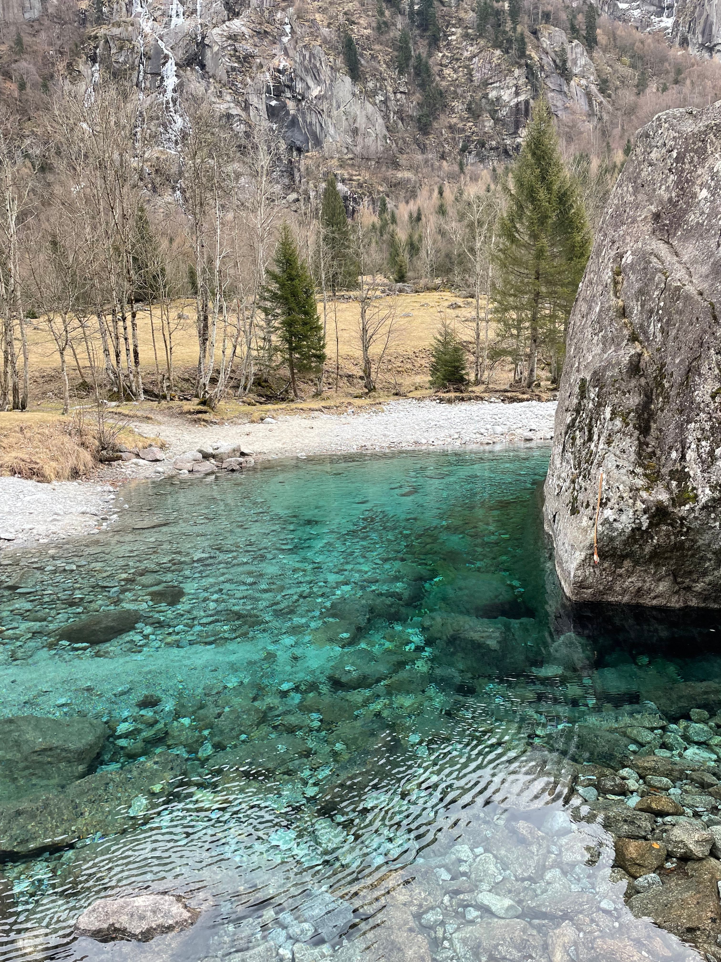 Stunning emerald pool with rocky surroundings in Val Masino, Italy.