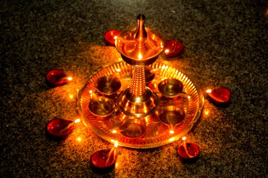 Beautiful traditional arrangement of Diwali lamps radiating warm golden light on a granite surface.