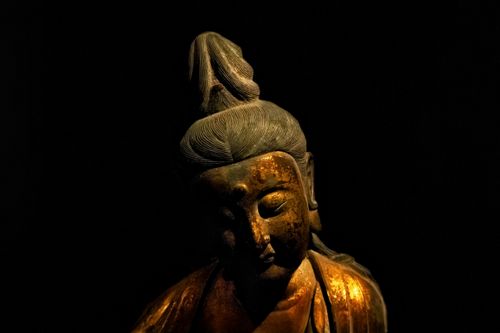 Free A contemplative Buddhist statue in low light evokes spirituality and peace. Stock Photo