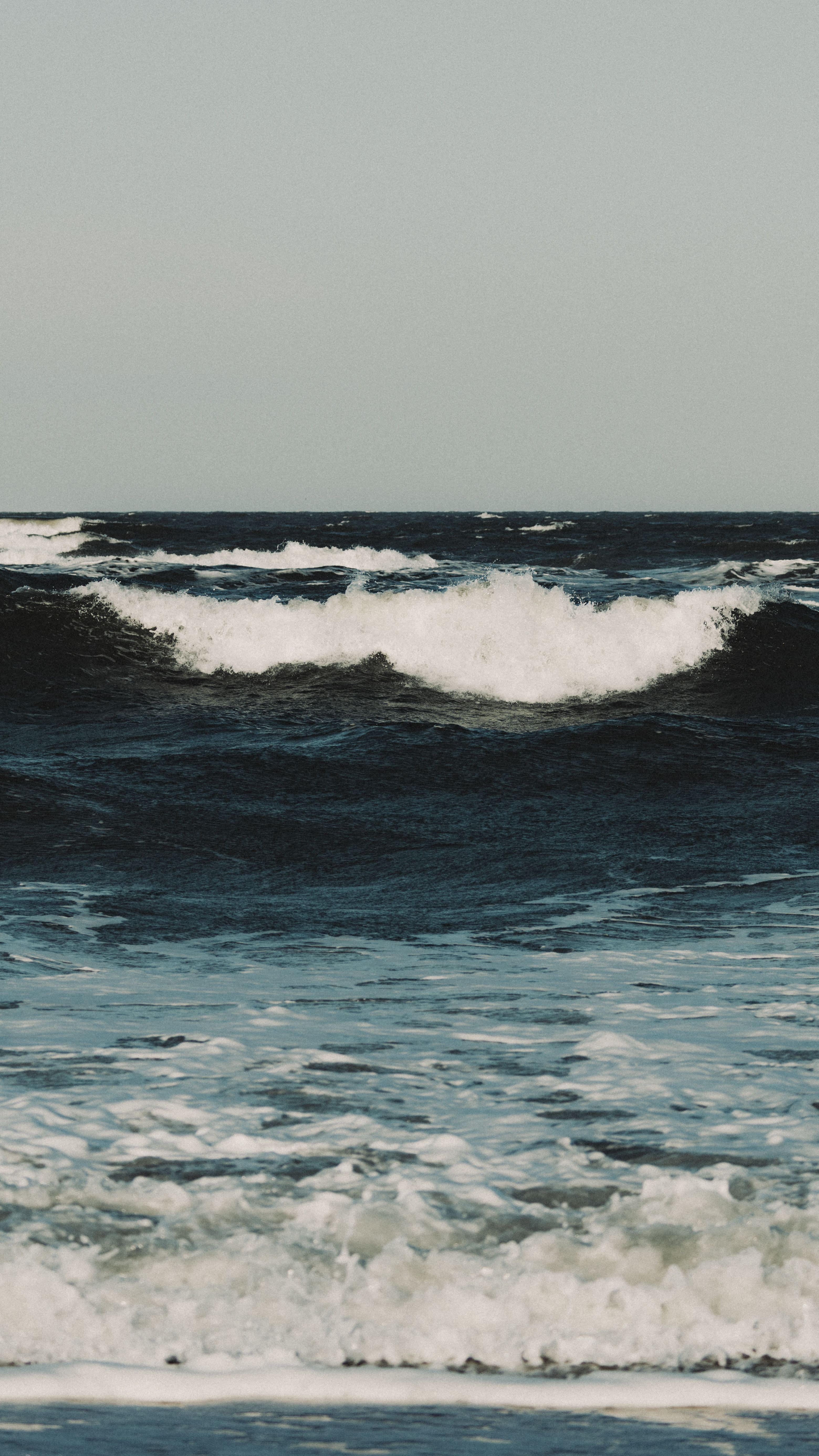 Powerful waves crashing in the sea with a cloudy sky. Captivating nature and seascape view.