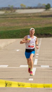 Athlete running a marathon outdoors on a sunny day, wearing race bib 014. — photo by Alin Serban