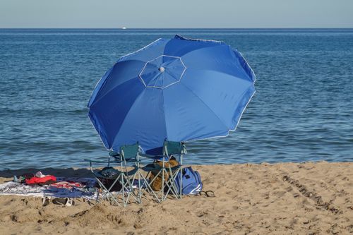 Free Scenic view of beach chairs and umbrella on the sandy shores of El Campello, Spain. Stock Photo