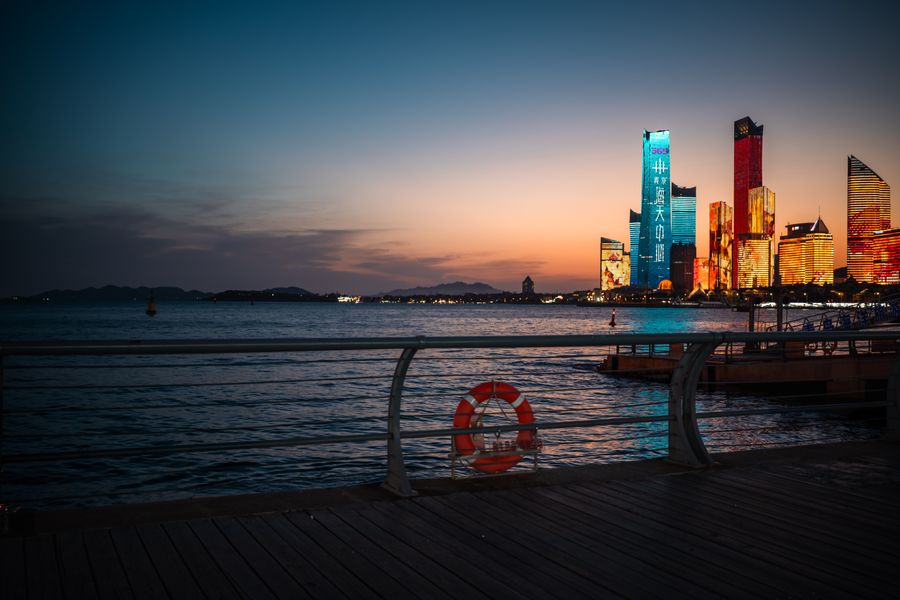 Qingdao's harbour frontage as the city's port lights come on at dusk