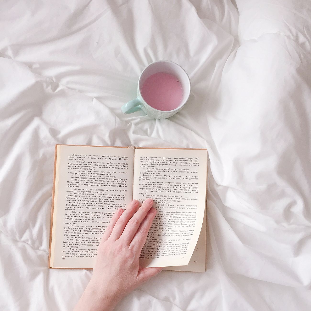 hand turning book pages with a cup