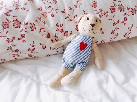 一只可爱的泰迪熊，心形图案，正躺在卧室里舒适的花卉枕头上