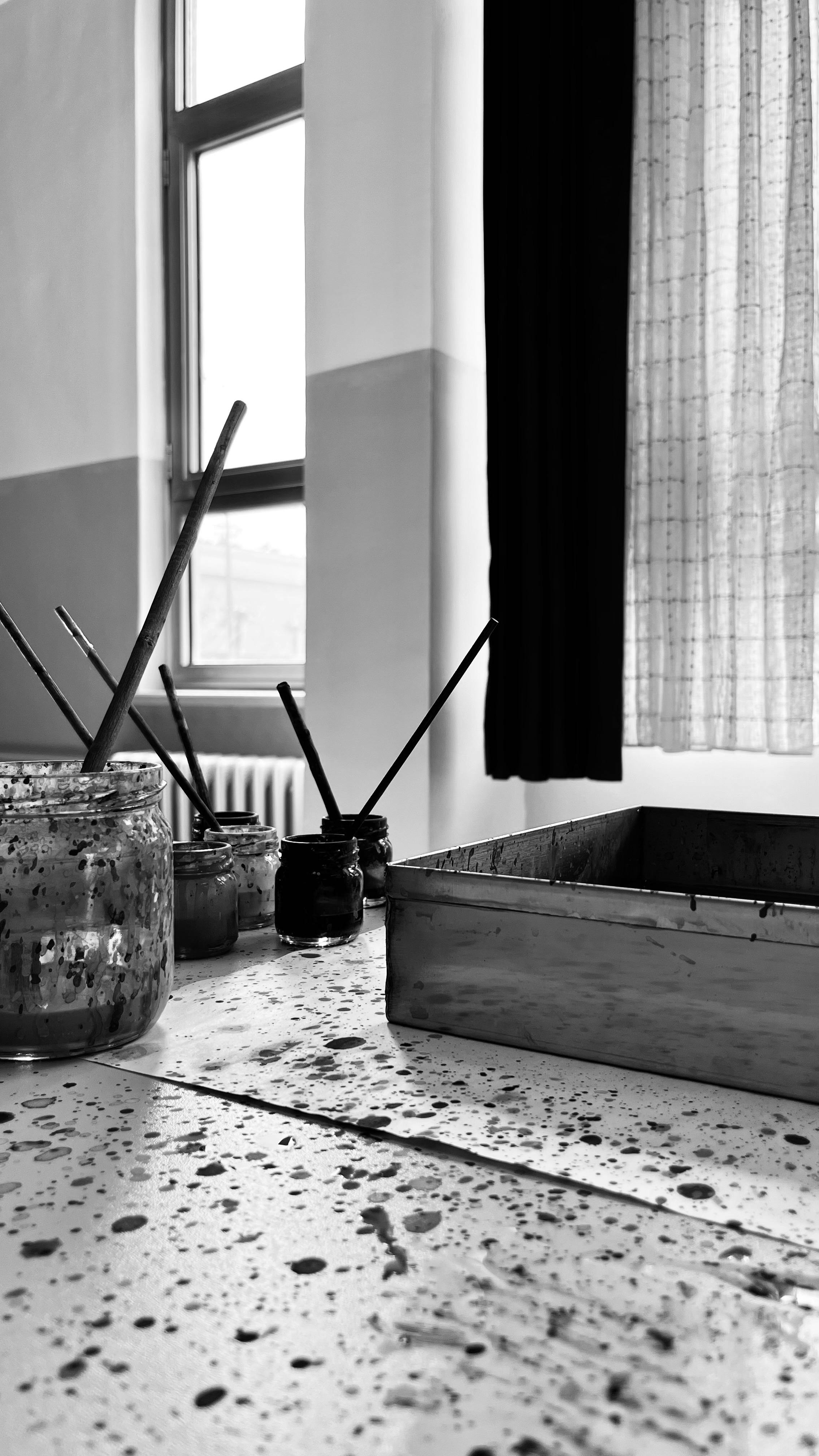 A serene art studio with paint jars and brushes lit by soft window light.