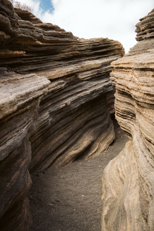 Free Explore stunning rock layers in Lanzarote's rugged canyon landscape. Stock Photo