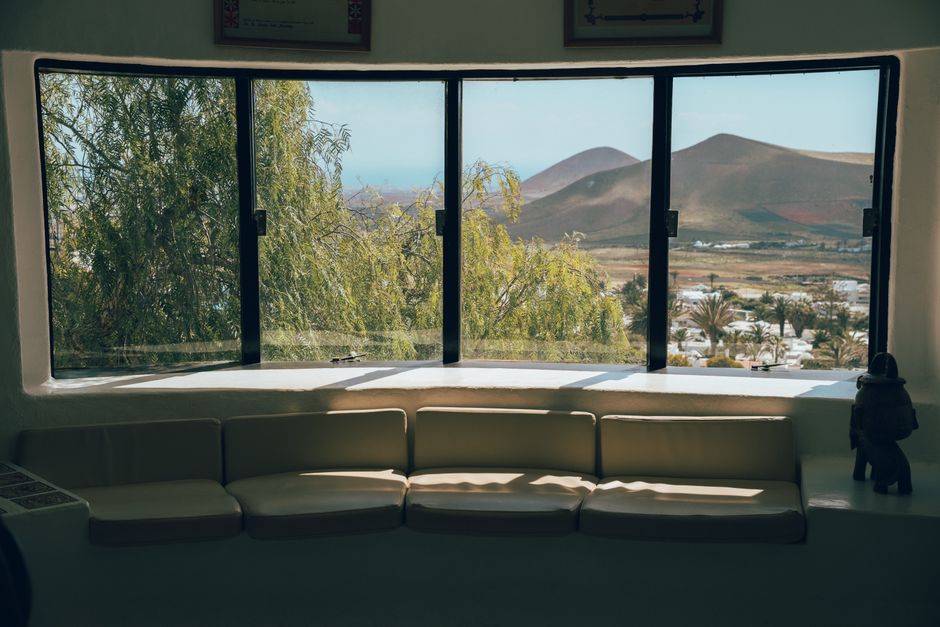 Cozy interior view showcasing Lanzarote's beautiful landscape through large windows.