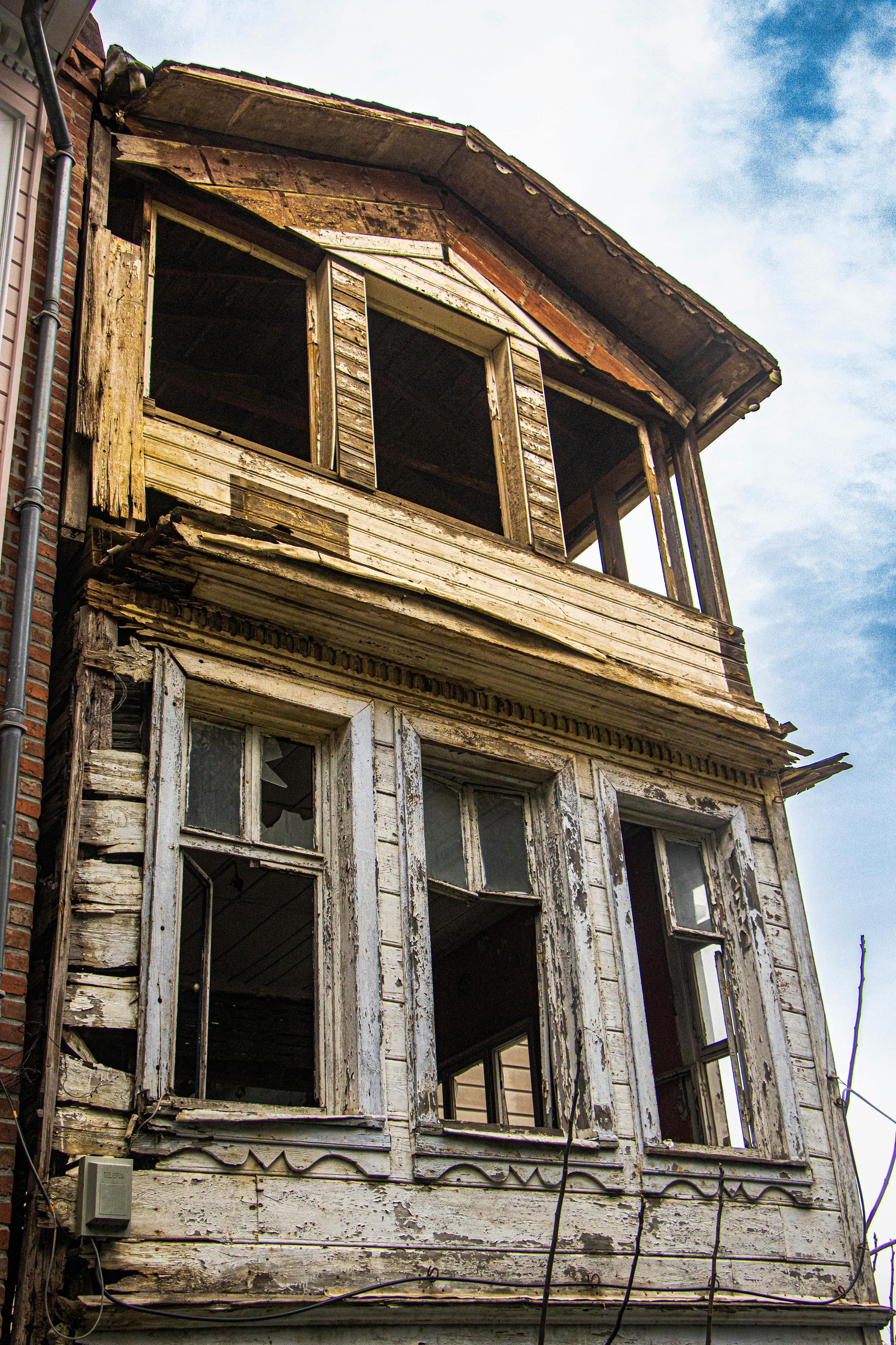 Close-up of an old, abandoned wooden building with broken windows.