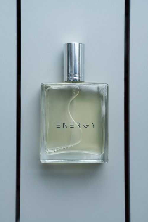 Free Bottle of 'Energy' perfume with sleek minimalist design on white background. Stock Photo