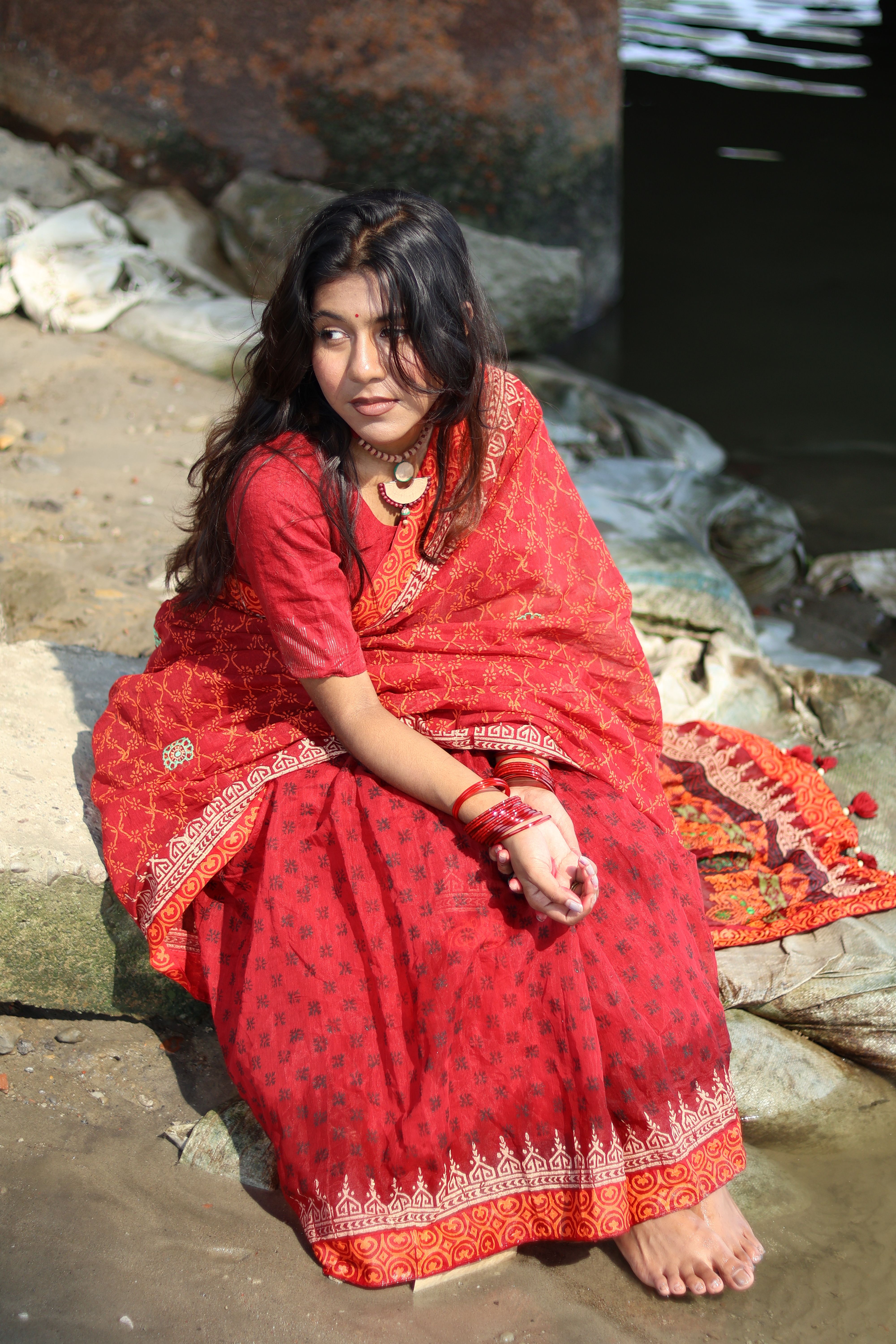 Woman in Traditional Red Attire by Riverside · Free Stock Photo