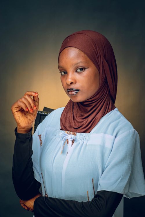 Free Portrait of a confident young woman wearing a hijab and blue top in a studio setting. Stock Photo