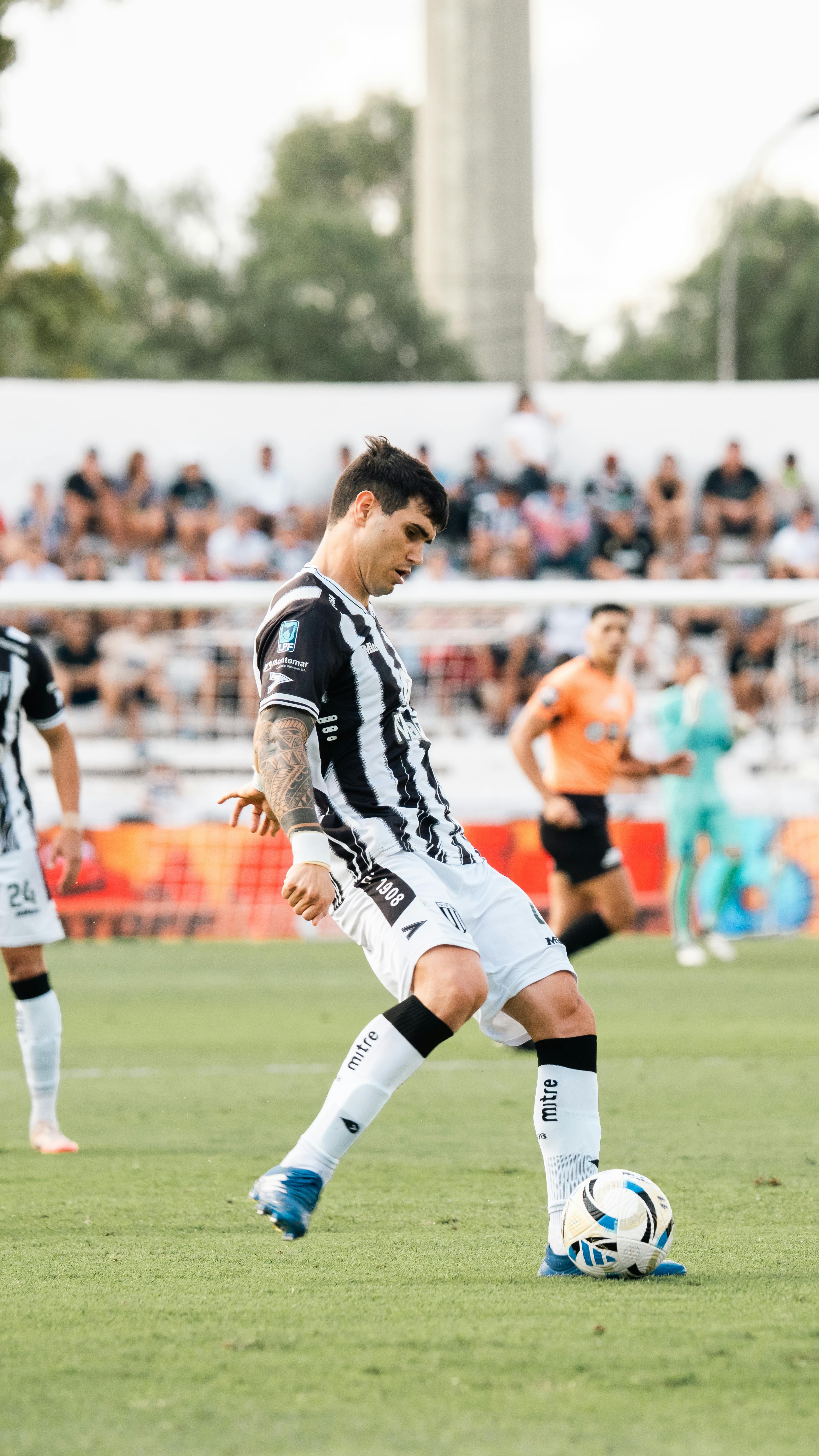 Dynamic shot of soccer player in action on the field during a live match.