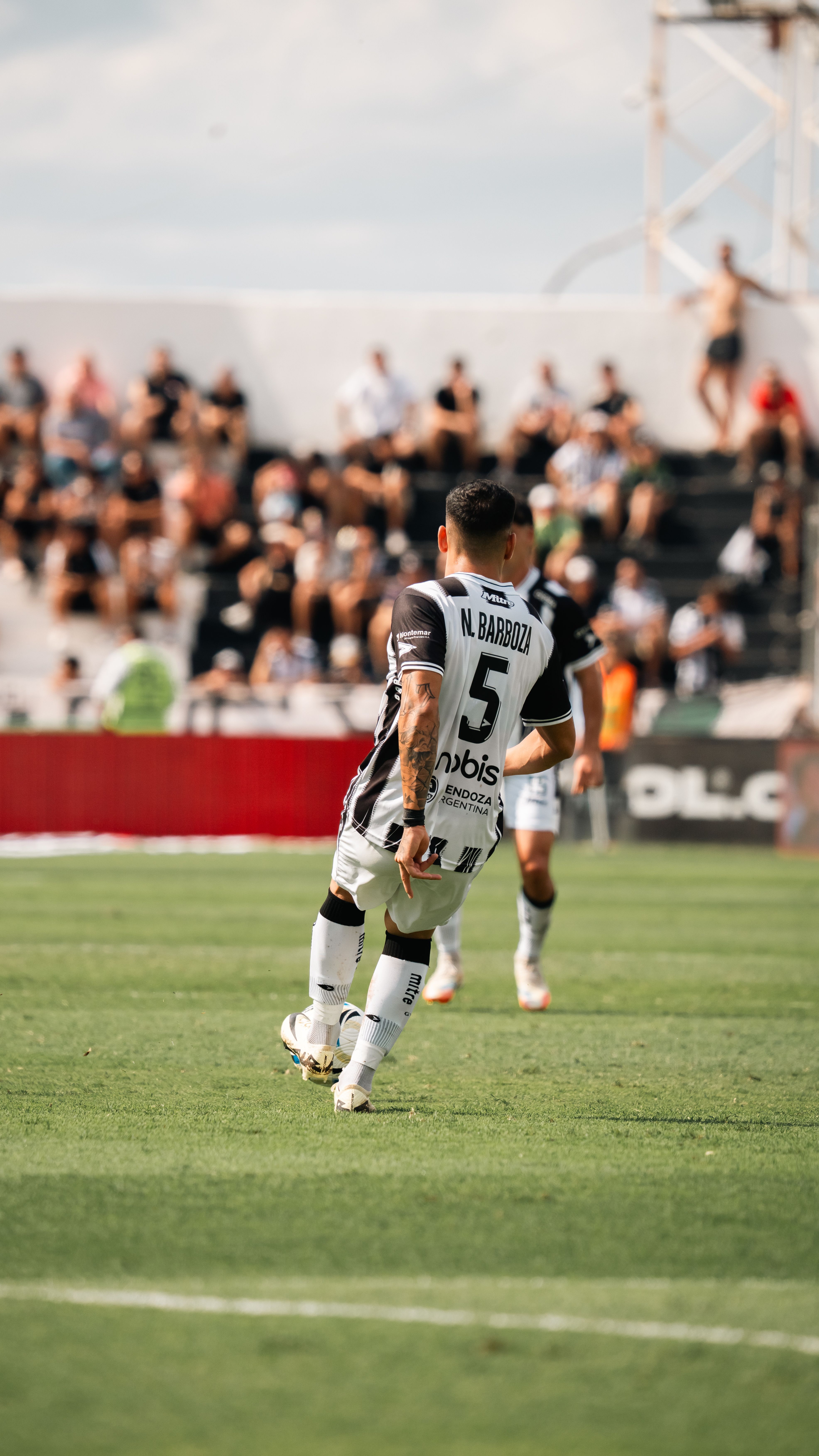 Dynamic soccer game capturing a player on the field under a sunny sky.