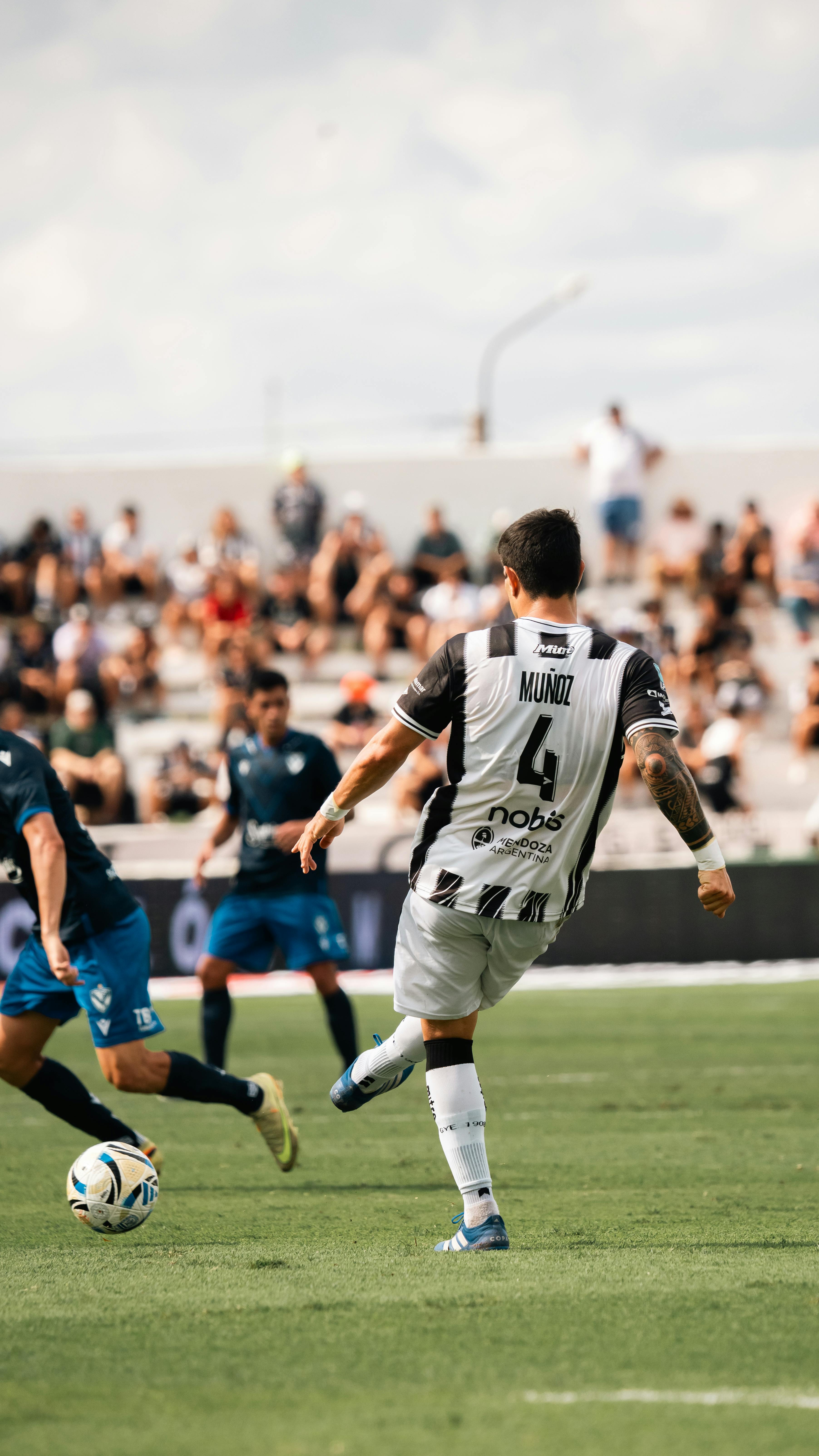 Action shot of a lively soccer match in a sunny outdoor stadium with players in motion.