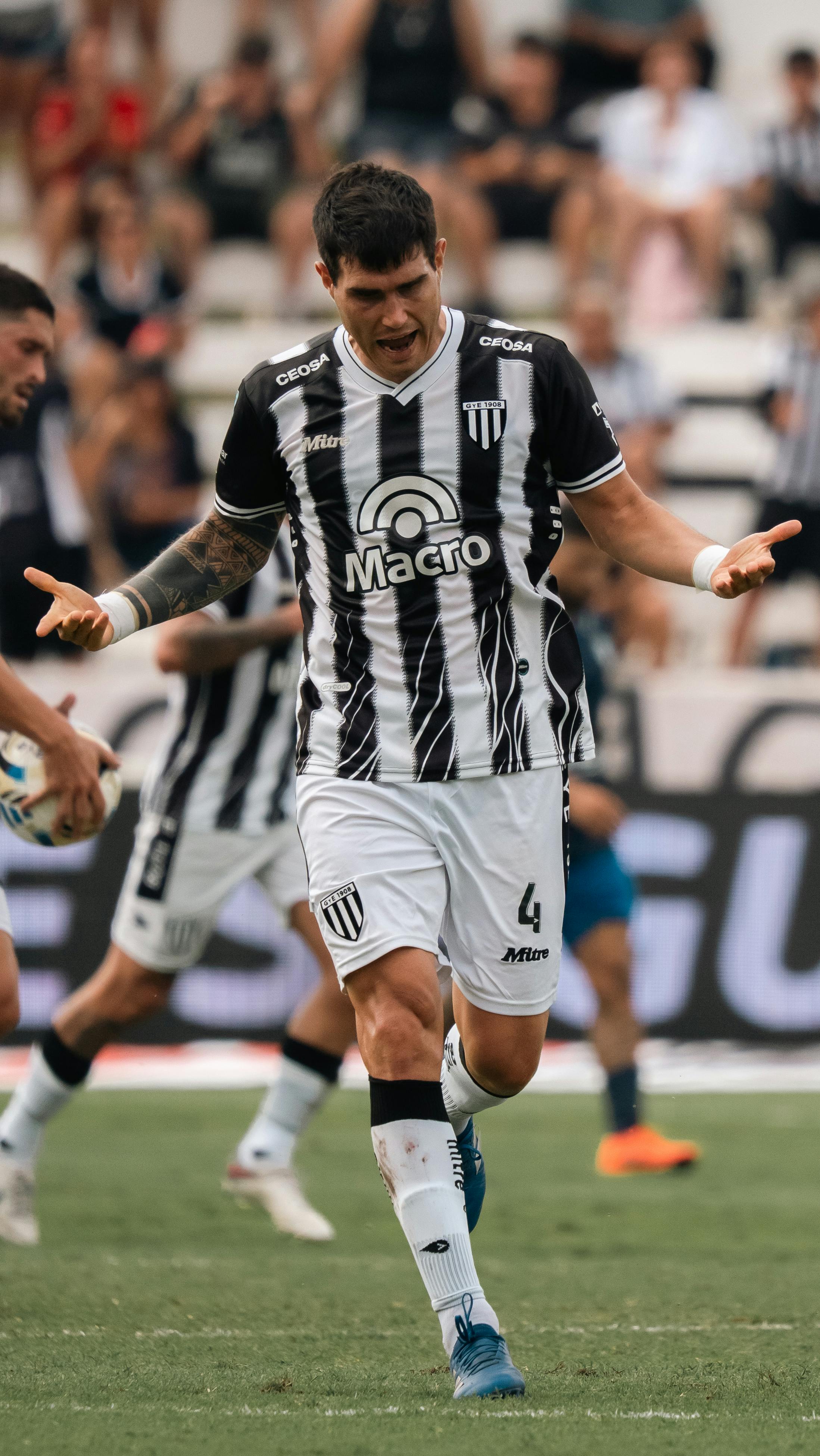 Soccer player expressing emotions during a match on a sunny day.