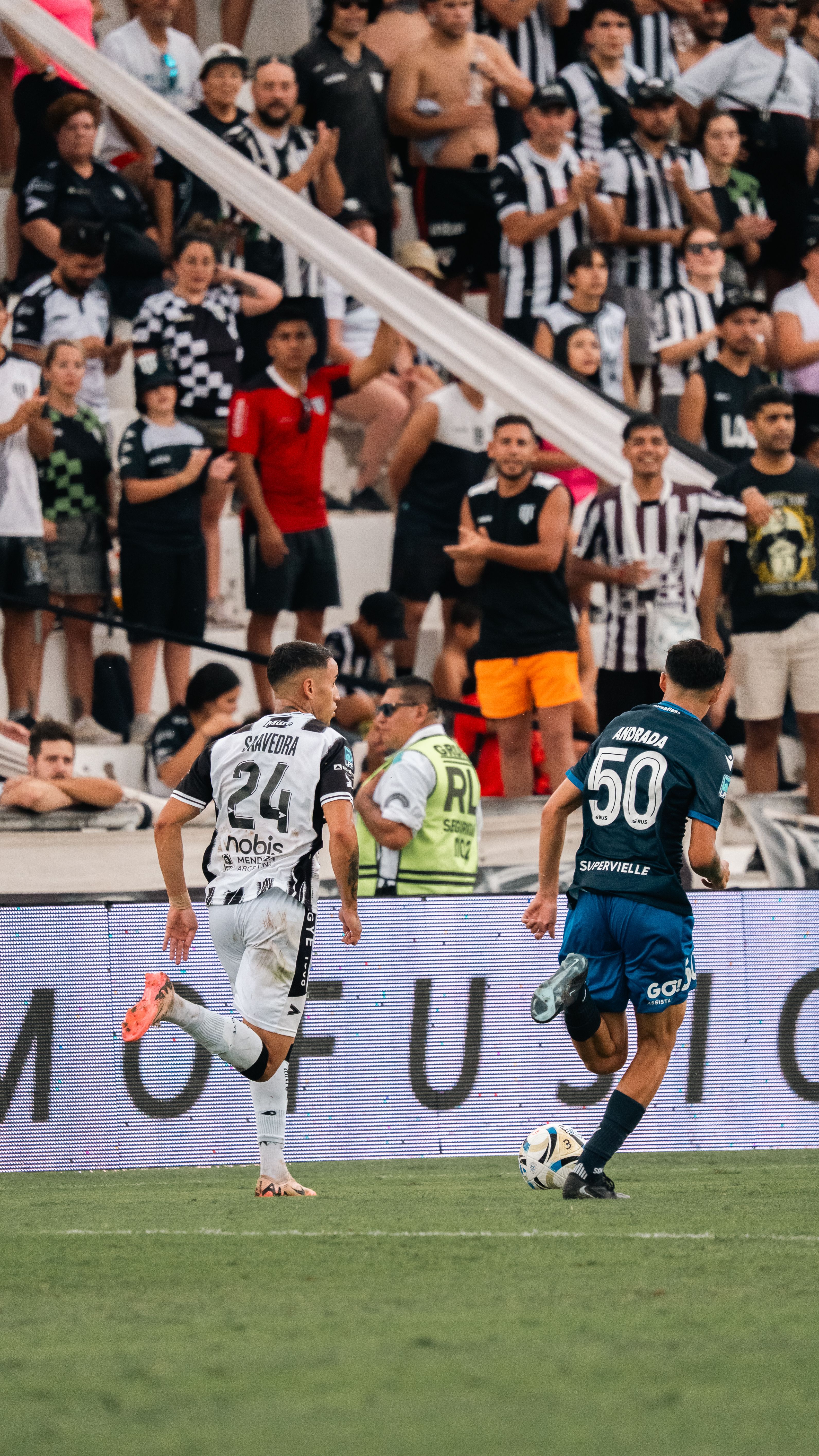 A dynamic soccer match with focused players and a vibrant crowd in the background.