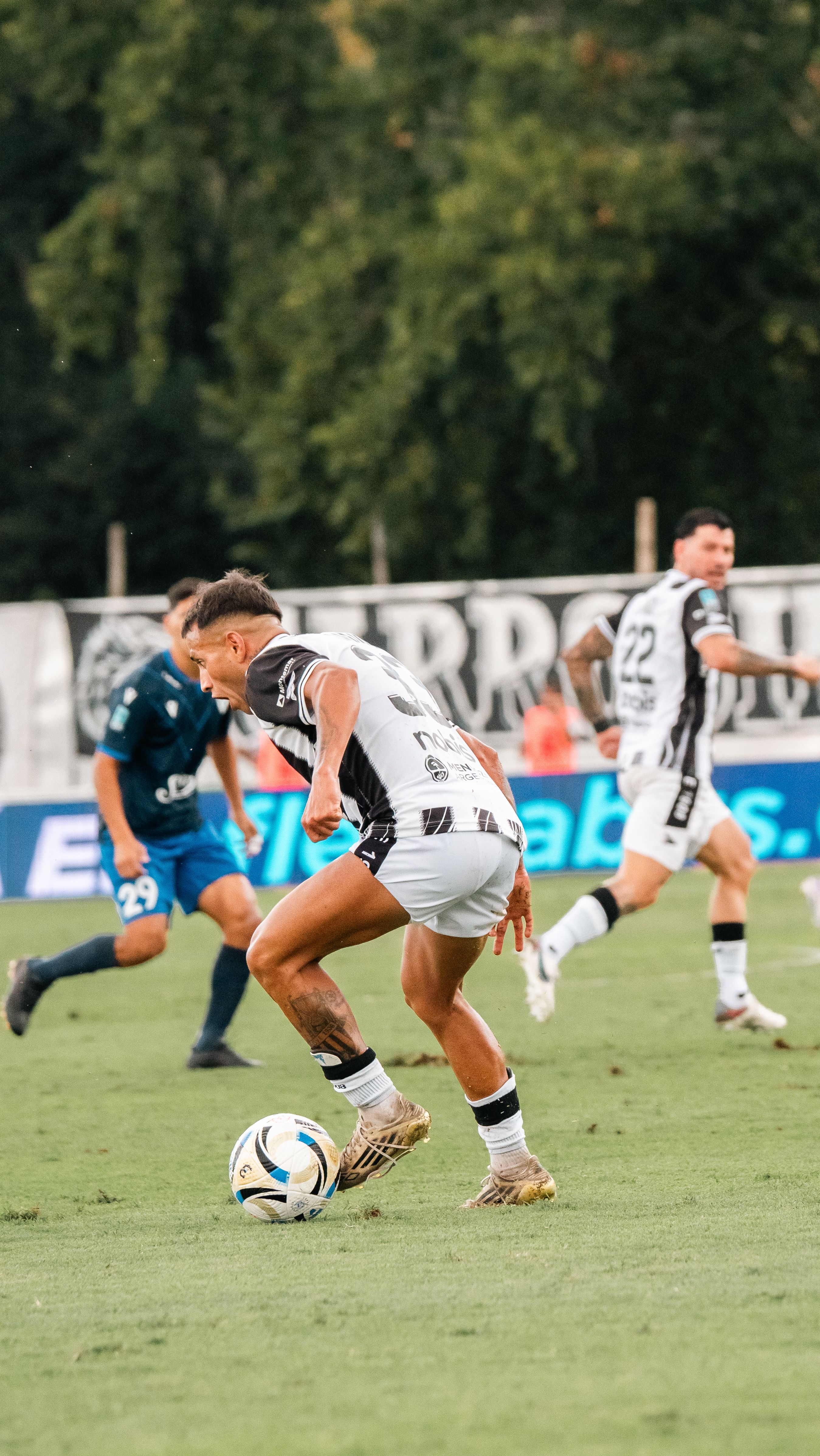 Dynamic shot of soccer players competing fiercely during a match on a green field.