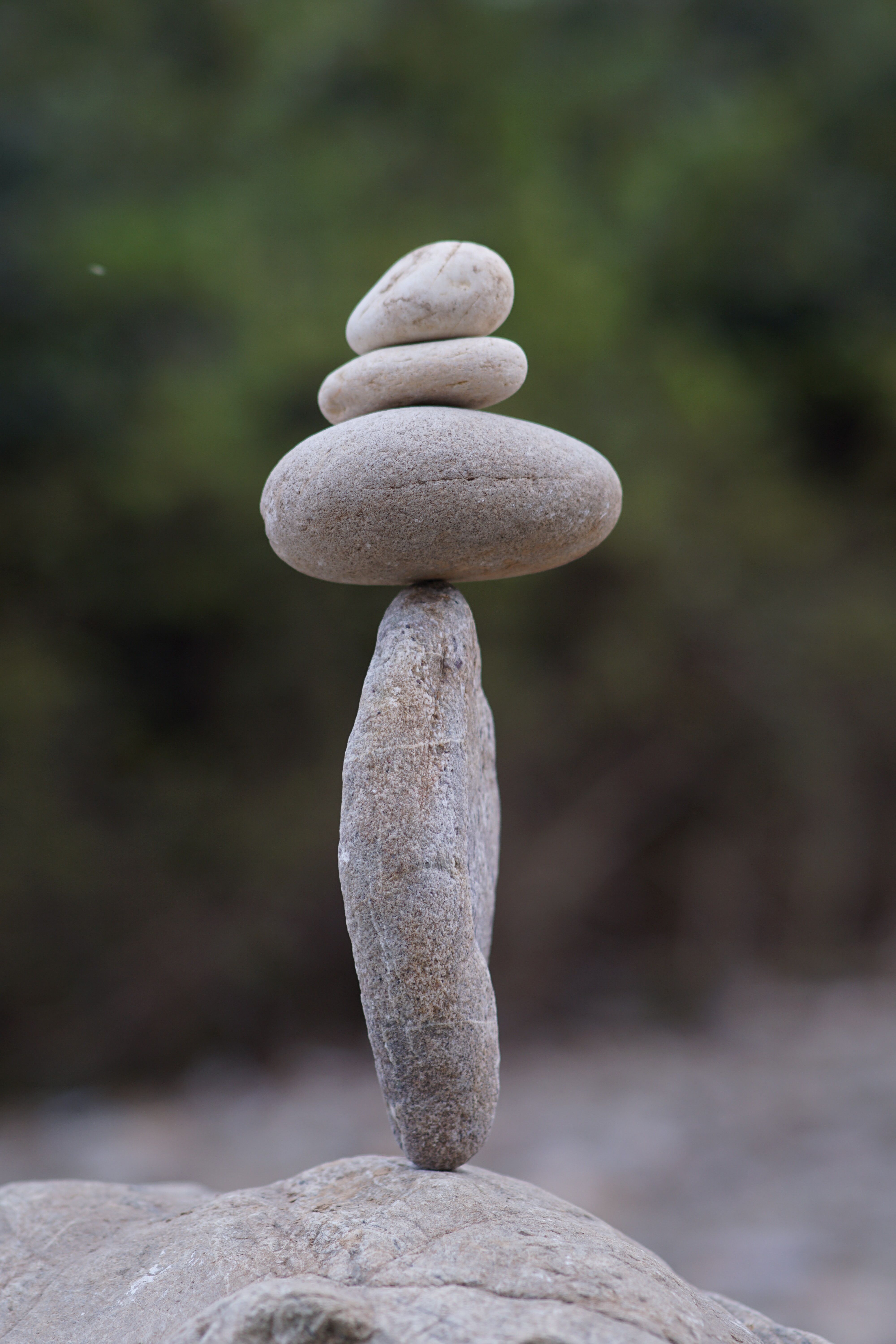 A stack of balanced pebbles in an outdoor setting, symbolizing tranquility and meditation.
