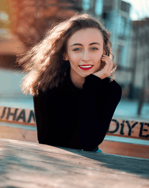 Woman Leaning on Wooden Table