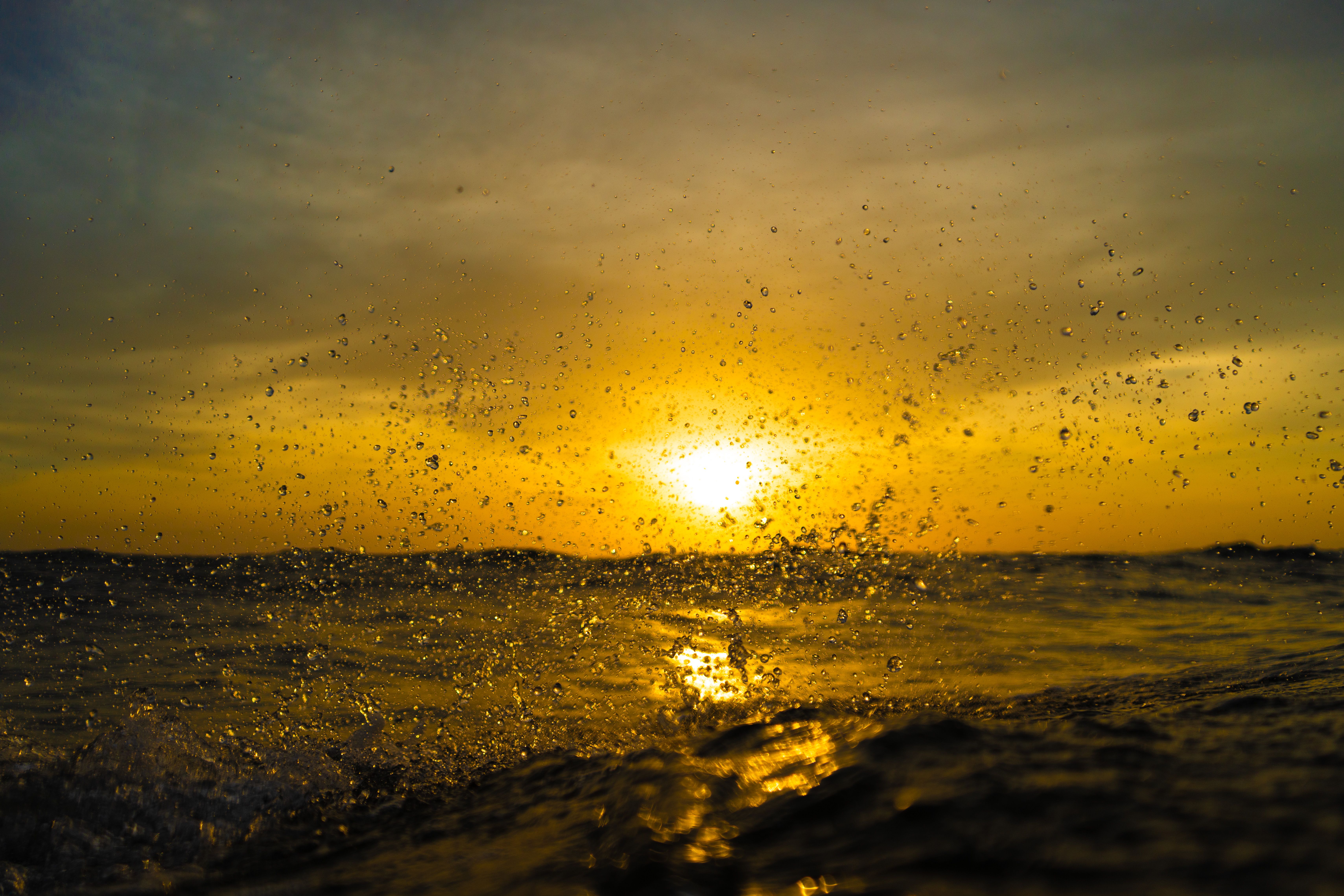 Golden Sunset Over Ocean with Splashing Waves · Free Stock Photo