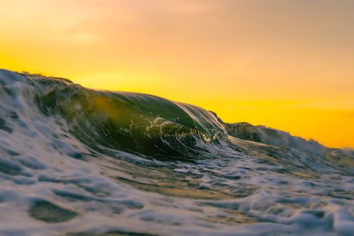 Free Dramatic ocean waves at sunset with golden sky and foamy water, captured outdoors. Stock Photo