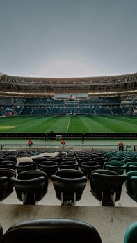 Wide-angle view of an empty football stadium, perfect for sports-themed projects.