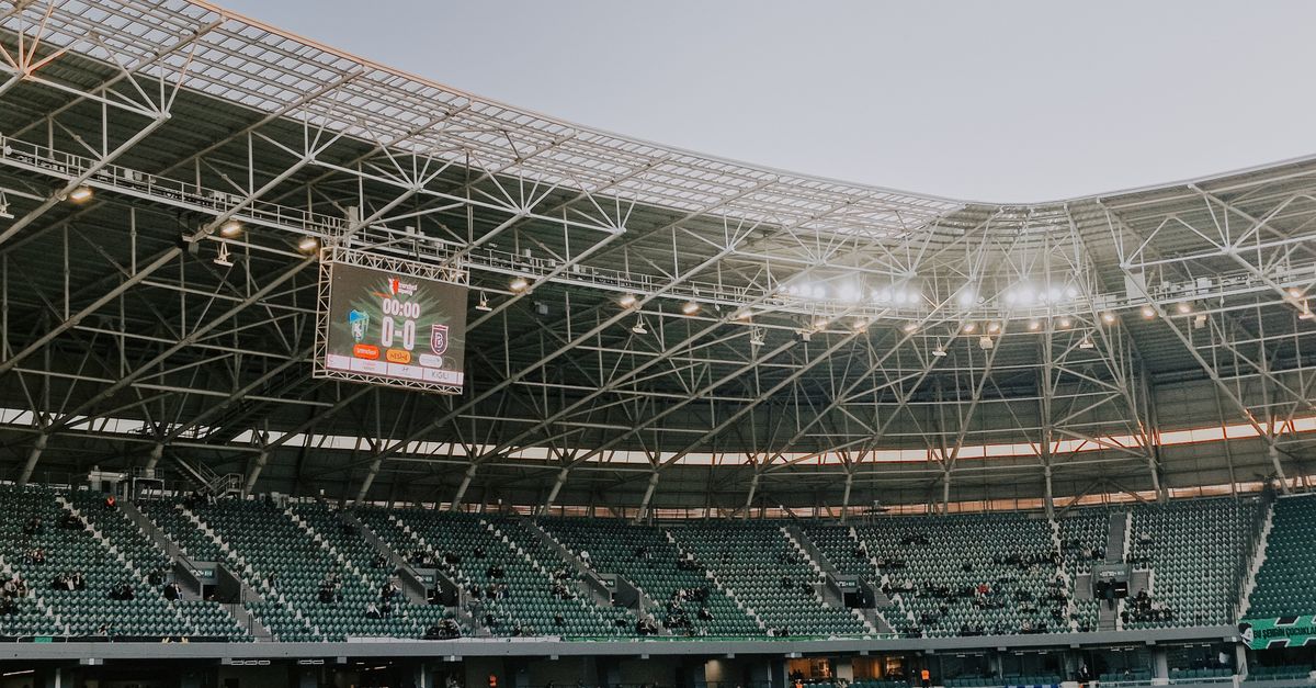 futuristic stadium with holographic scoreboards and drones flying overhead