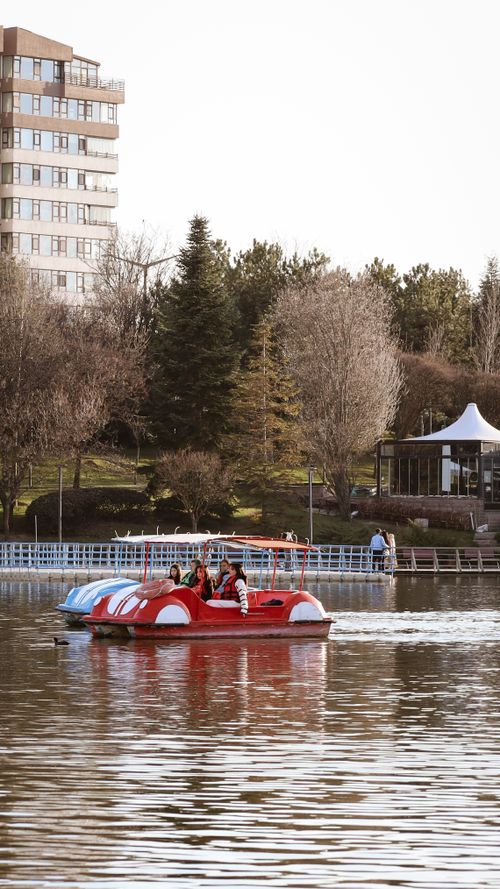 Free A vibrant view of people enjoying a pedal boat ride on a lake in Ankara during springtime. Stock Photo