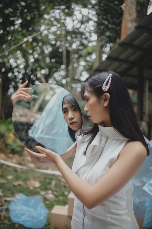 Woman Looking on Round Mirror Glass