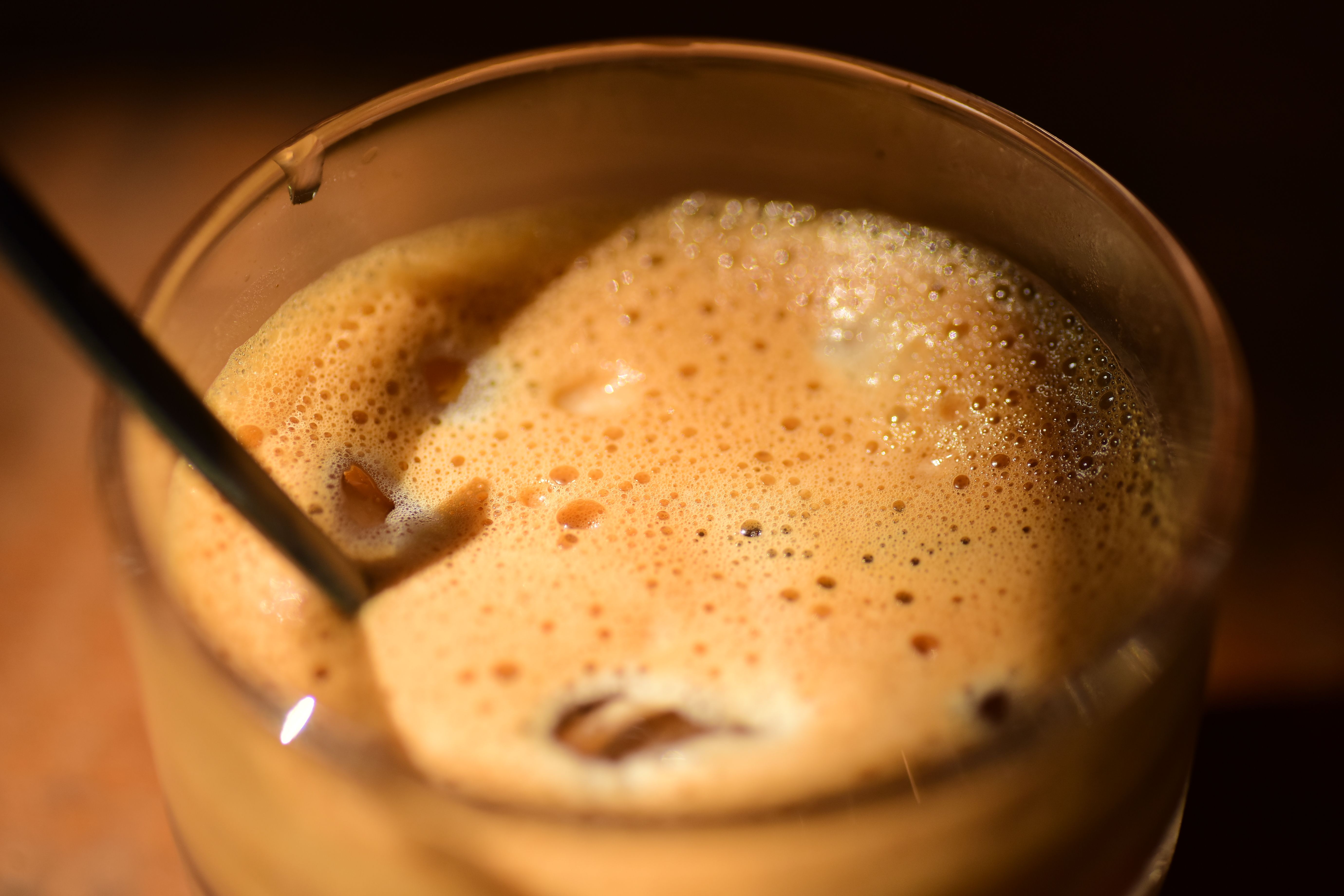 Creamy cold foam topping on iced coffee in a glass