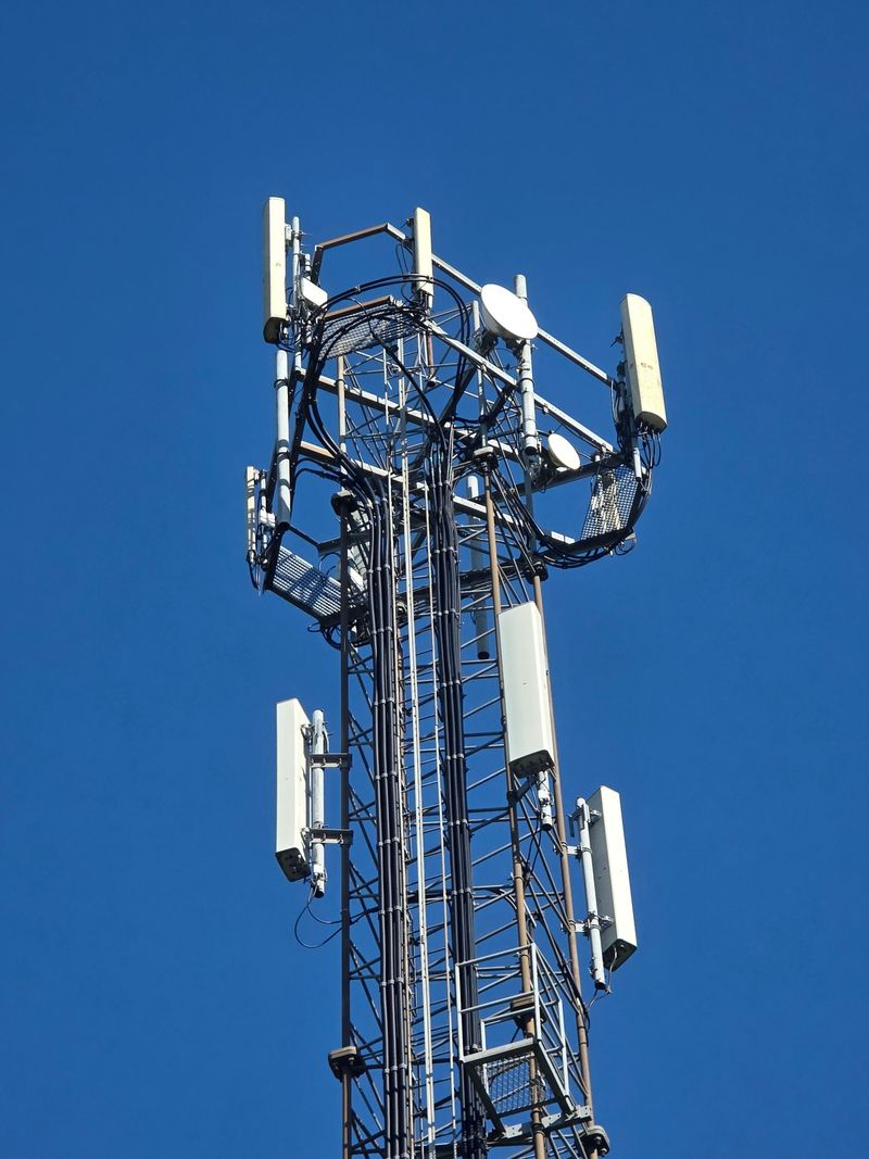Cellular base station tower with sector antennas and microwave dishes
