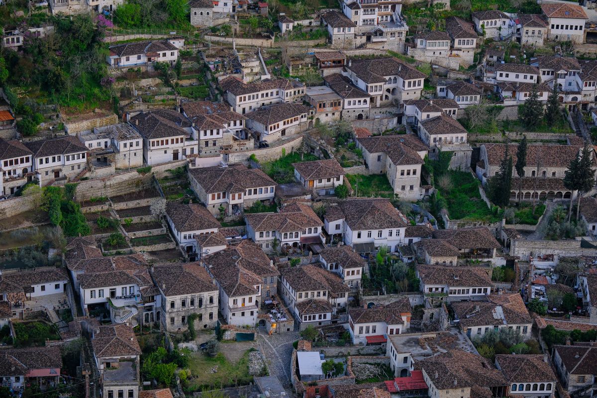 Berat's Ottoman-era houses cascade down the hillside — "the city of a thousand windows," a UNESCO World Heritage Site.