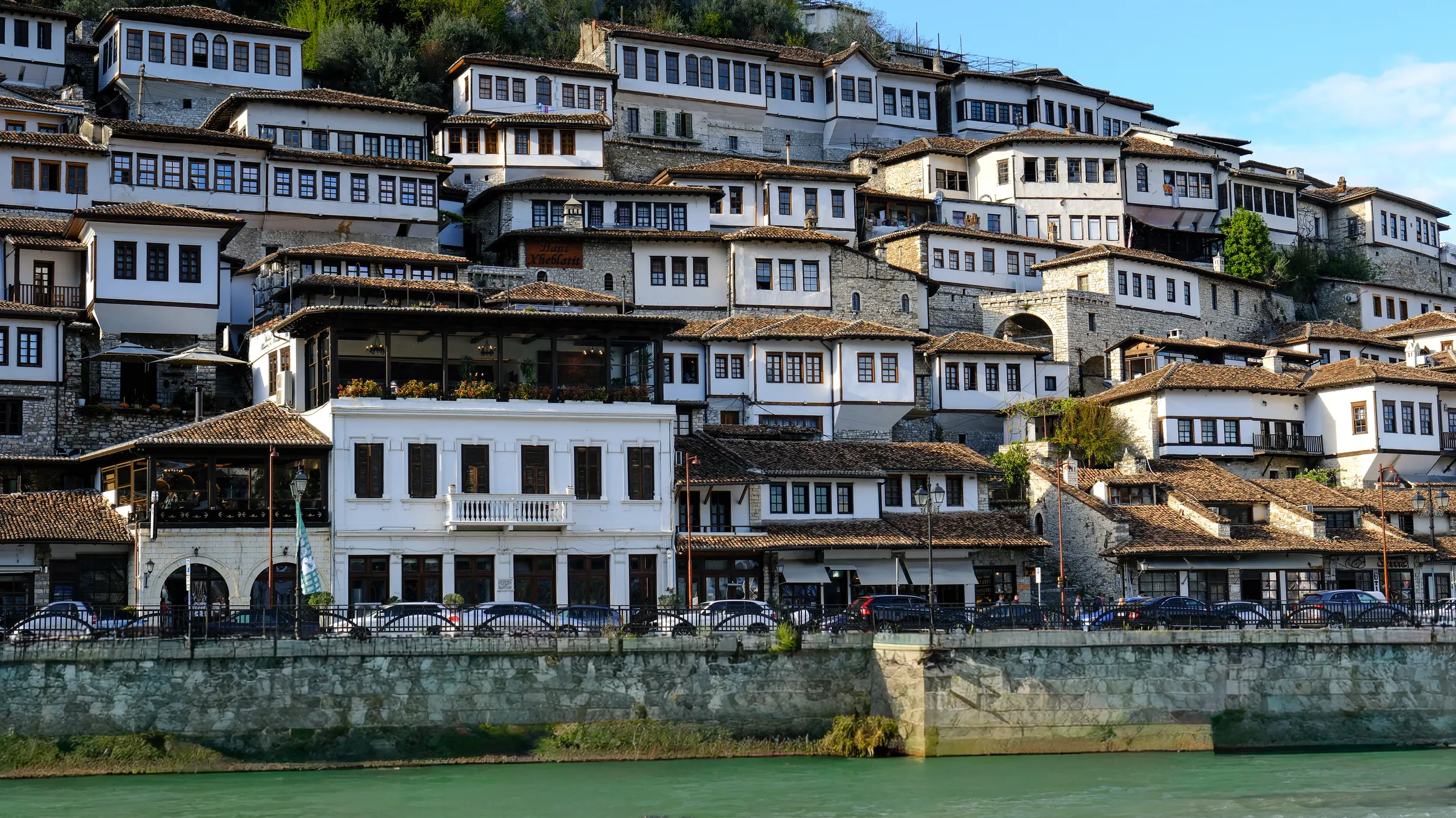 Rumah-rumah Ottoman putih bertingkat di lereng bukit Berat, Albania