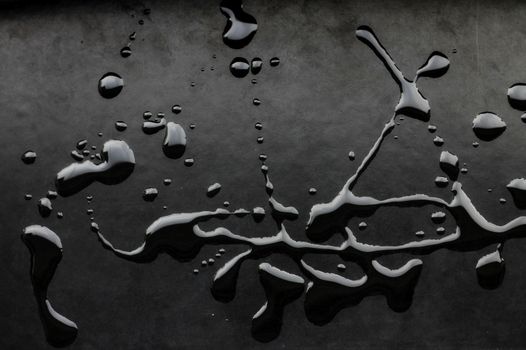 Artistic display of water drops on a textured dark background.