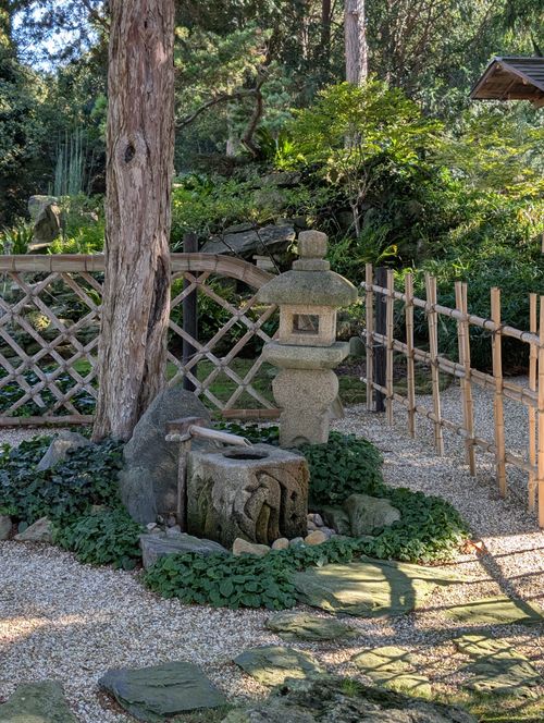 Free Tranquil Japanese garden featuring a traditional stone lantern and lush greenery. Stock Photo