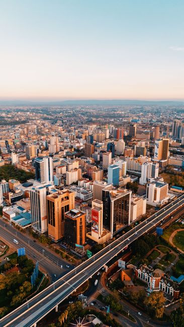 Breathtaking aerial view of Nairobi, Kenya's skyline with modern skyscrapers and roads at sunset.