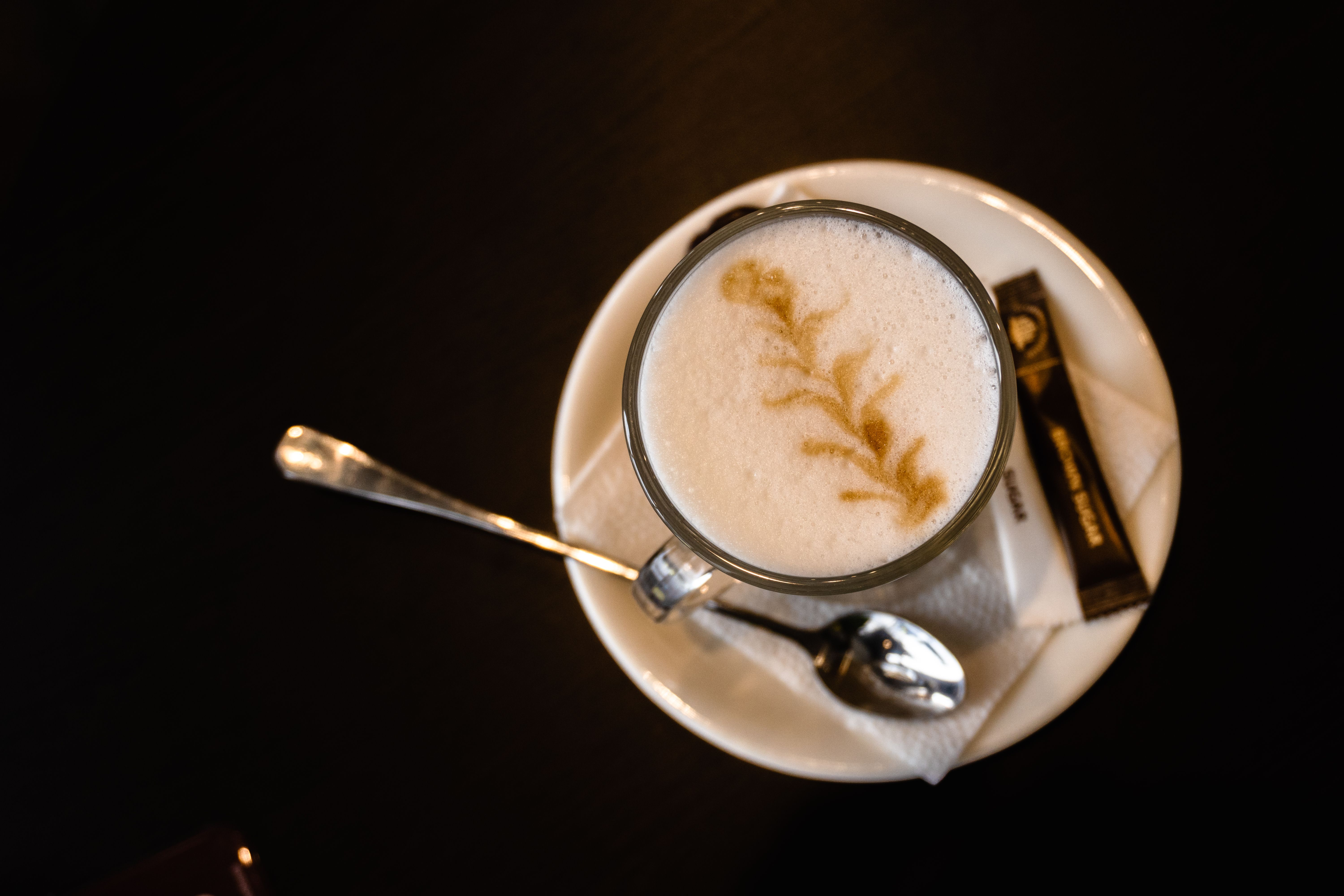 A steaming cappuccino served in a cozy Swiss cafe, with a view of a city street.