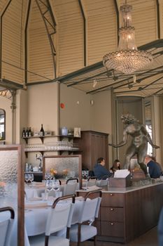 Chic restaurant interior featuring a striking art sculpture and elegant chandelier.