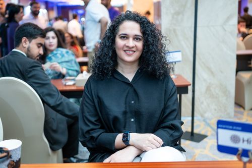 Free A confident businesswoman sits at a conference in Islamabad, Pakistan, amidst a professional crowd. Stock Photo