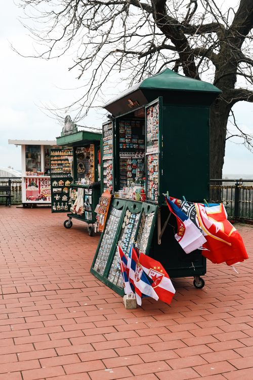 Free Souvenir stalls displaying flags and magnets on a tiled pathway in Novi Sad, Serbia. Stock Photo
