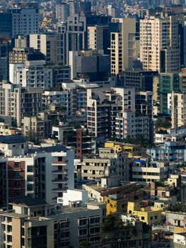 Aerial view of a densely packed urban skyline showcasing diverse architecture under a clear blue sky.