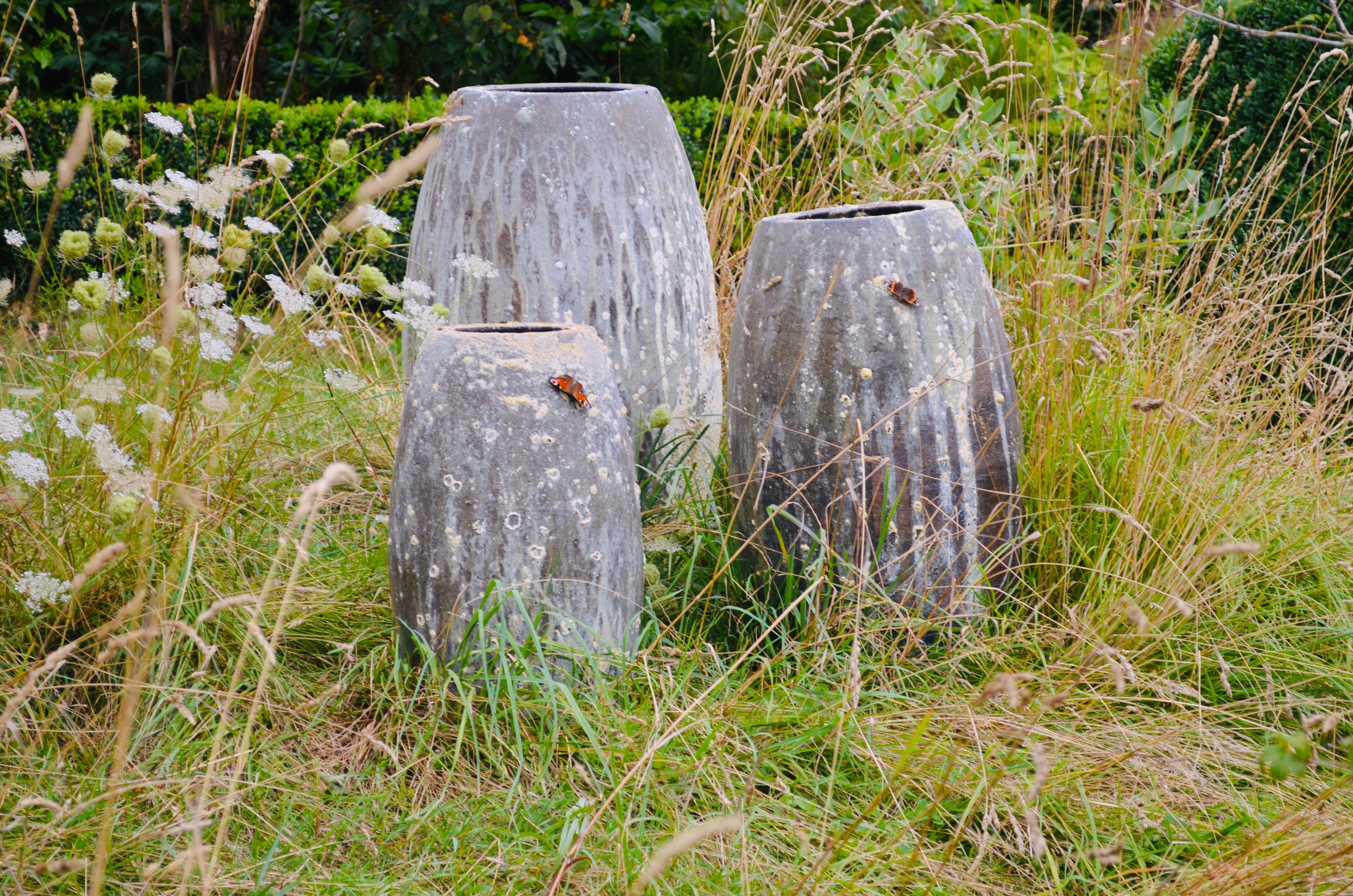 Afvalkunstwerk van plastic flessen in bloementuin.